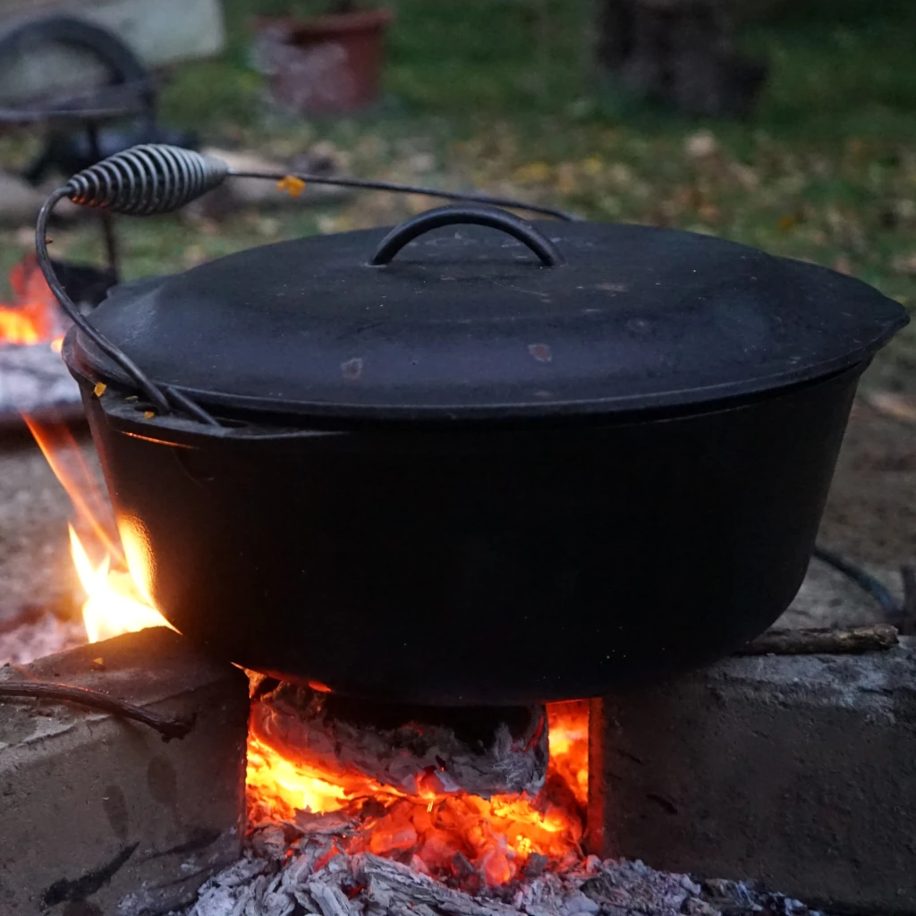 ein Topf mit einem Deckel auf einem Feuer